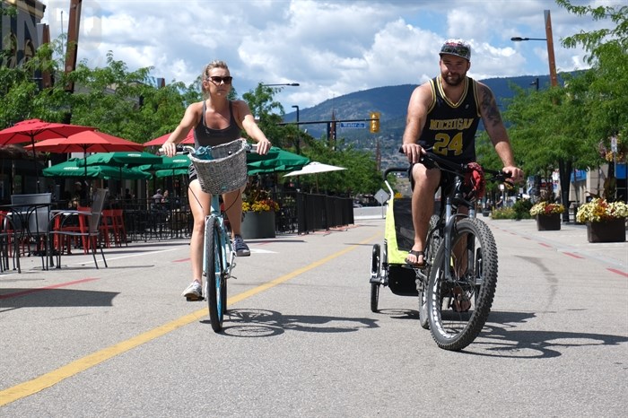 A couple uses the open road along Bernard Avenue to cycle.