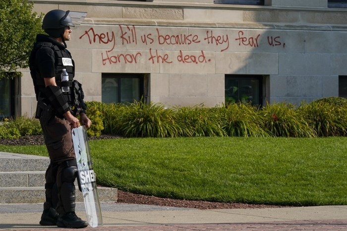 Police in riot gear stand outside the Kenosha County Court House Monday, Aug. 24, 2020, in Kenosha, Wis. Protests broke out late Sunday night after a police shooting.