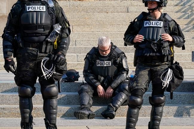 Police in riot gear stand outside the Kenosha County Court House Monday, Aug. 24, 2020, in Kenosha, Wis. Protests broke out late Sunday night after a police shooting. 