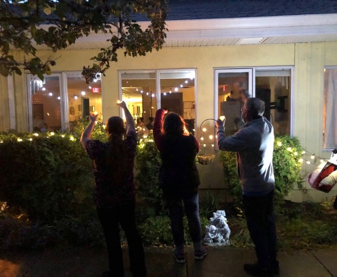 As live music played outside the Pine Grove Care Centre families and residents waved to each other and held their candles high.