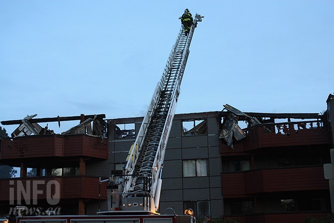 A Penticton firefighter climbs an aerial ladder to assess the top floor of Clarence House on Elm Avenue.