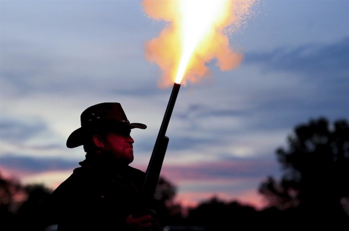 Cast member Dean Stout fires a blank bullet out of his shotgun as he attempts to scare visitors waiting in line to enter Terror Town, Saturday, Oct. 17, 2020, in Williamsburg, Ohio. 