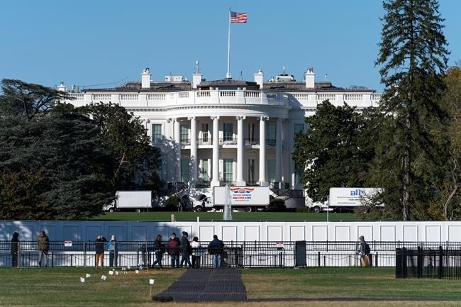 People look at the South Lawn of the White House, Monday, Nov. 2, 2020, in Washington, the day before the U.S. election. A towering barrier against protesters surrounds the White House as Americans deliver a final verdict on their next commander-in-chief.
