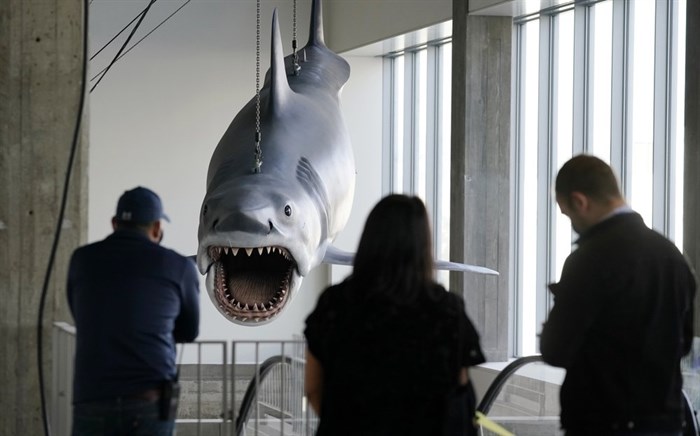 Museum workers look on as a fiberglass replica of Bruce, the shark featured in Steven Spielberg's classic 1975 film 