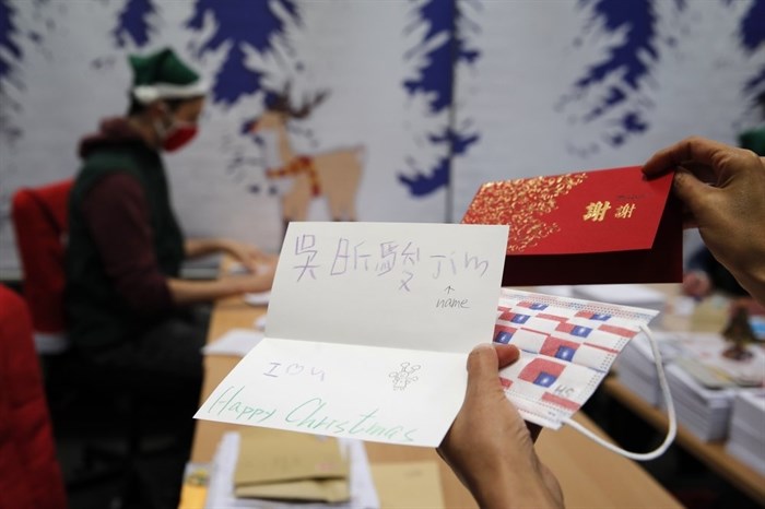A postal worker shows an envelope from Jim of Taiwan, who sent a face mask inside the letter he sent and wrote 