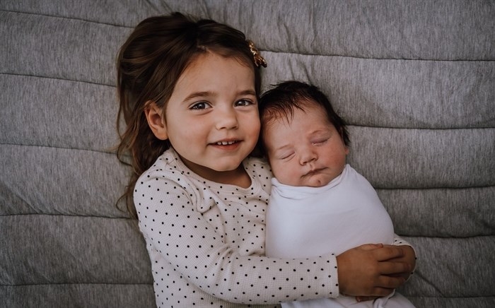 Three-year-old Macey Kraushar holds her baby sister Georgia Kraushar.