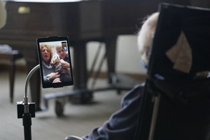 Jerry Woloz, 79, visits with his family and a new dog via a tablet at The Hebrew Home at Riverdale in New York, Wednesday, Dec. 9, 2020. Video and drive-by visits are the only types available at this time due to fears of spreading COVID-19 within the nursing home. New dog recruits are helping to expand the nursing home's pet therapy program, giving residents and staff physical comfort while human visitors are still restricted. 