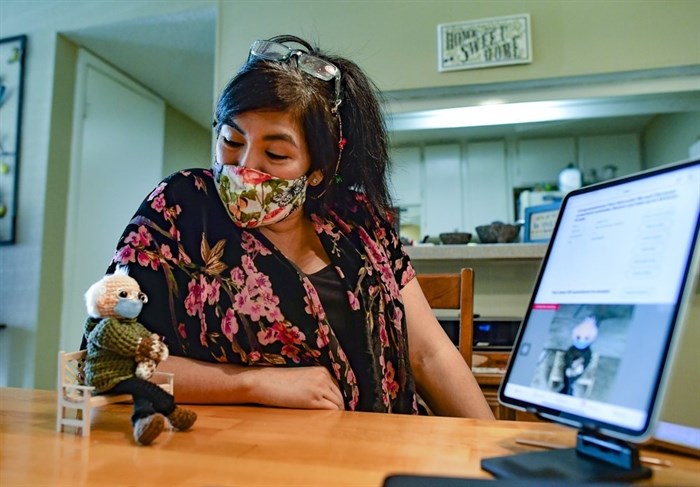 Tobey King speaks to her crochet Bernie Sanders doll as the bidding continues on eBay on Tuesday, Jan. 26, 2021 in Corpus Christi, Texas. The doll sold for $20,300, and all of the proceeds are being donated to Meals on Wheels.