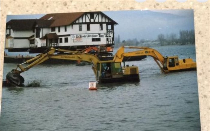 The barge got stuck in shallow water so an excavator was brought in to dig a trench so it could make it to the shore.