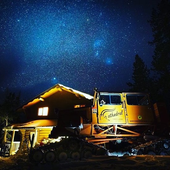 Cathedral Lakes Lodge under a winter night sky.