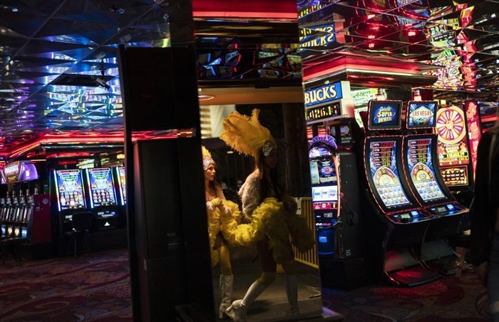 Buskers dressed as showgirls walk into a casino along the Las Vegas Strip in Las Vegas, Feb. 10, 2021. With the ongoing coronavirus pandemic curtailing tourism, visitors have found quiet gambling floors, shuttered showrooms and inexpensive rates. 