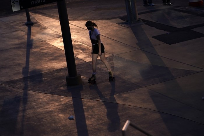 A woman roller skates along the Strip in Las Vegas, Feb. 10, 2021. The toll of the coronavirus is reshaping Las Vegas almost a year after the pandemic took hold. The tourist destination known for bright lights, big crowds, indulgent meals and headline shows is a much quieter place these days. 