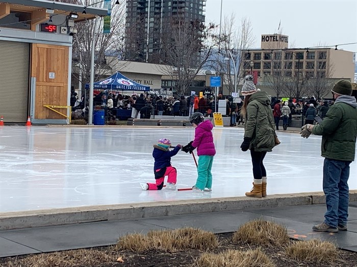 Darcy Robson, from Lake Country, and his family skate on Stuart Park's ice rink Saturday, Feb. 13, beside a COVID-19 anti-restriction protest.