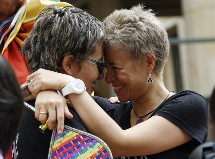 LGBT rights activists Sandra Rojas, left, and Adriana Gonzalez celebrate a Constitutional Court decision to give same-sex couples marriage rights, in front of the Justice Palace in Bogota, Colombia, Thursday, April 7, 2016.