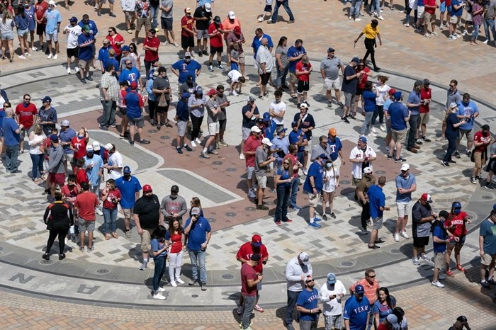 Fans line up to enter Globe Life Field before the Texas Rangers home opener baseball game against the Toronto Blue Jays Monday, April 5, 2021, in Arlington, Texas. The Texas Rangers are set to have the closest thing to a full stadium in pro sports since the coronavirus shutdown more than a year ago.