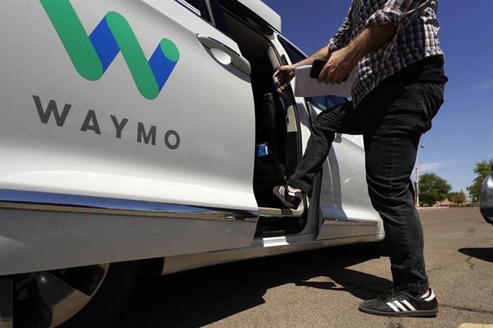 A Waymo minivan arrives to pick up passengers for an autonomous vehicle ride, Wednesday, April 7, 2021, in Mesa, Ariz. Waymo, a unit of Google parent Alphabet Inc., is one of several companies testing driverless vehicles in the U.S. But it's the first offering lifts to the public with no humans at the wheel who can take over in sticky situations.