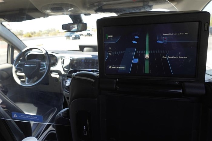 A Waymo minivan moves along a city street as an empty driver's seat and a moving steering wheel drive passengers during an autonomous vehicle ride, as passengers view a detailed viewing screen, Wednesday, April 7, 2021, in Chandler, Ariz. Waymo, a unit of Google parent Alphabet Inc., is one of several companies testing driverless vehicles in the U.S. But it's the first offering lifts to the public with no humans at the wheel who can take over in sticky situations. 