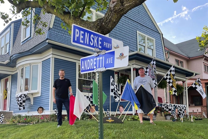 Chris Otto, left, of Seattle, and his brother Eric Otto, pose outside Eric's home, decorated for the Spectacle of Homes contest to be featured ahead of the Indianapolis 500 auto race, Thursday, May 27, 2021, in Indianapolis. Because the traditional parade has been canceled because of the coronavirus pandemic, drivers will instead cruise by homes that have been decorated to celebrate the 105th running of the race.