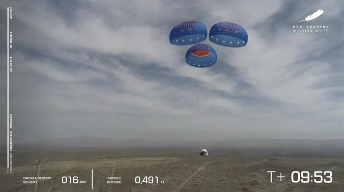 FILE - In this image from video made available by Blue Origin, the New Shepard capsule uses parachutes to land during a test in West Texas on Wednesday, April 14, 2021. Jeff Bezos will ride his own rocket into space next month, joining the first crew to fly Blue Origin. Bezos announced Monday, June 7, 2021, that not only will he launch July 20 from Texas, so will his fireman brother Mark. The highest bidder in a charity auction also will make the 10-minute up-and-down hop.