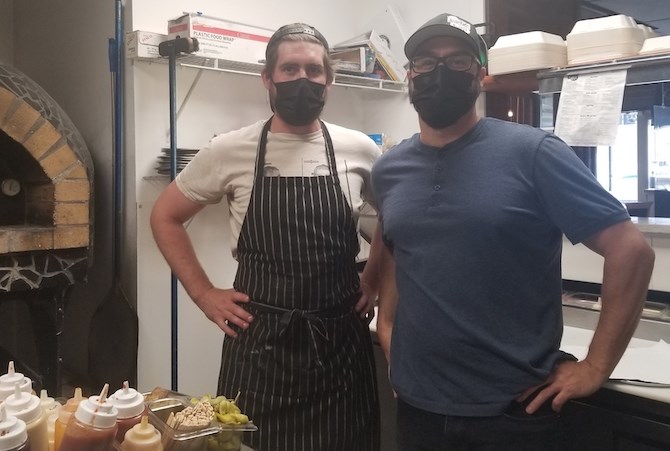 Alchemy Brewing Company owner Al Renner, right, and cook Josh Kenny pose for a photograph. The restaurant has recently won an online contest for the best wings in Kamloops.