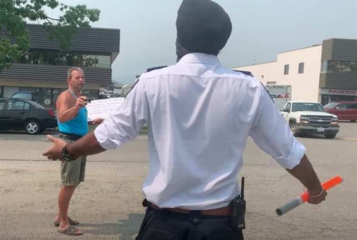 Kelowna protestor Bruce Orydzuk was seen yelling at Paladin Security guard Anmol Singh outside a Kelowna vaccination clinic, July 13, 2021. Singh received national praise for his calm manner in handling the protest.