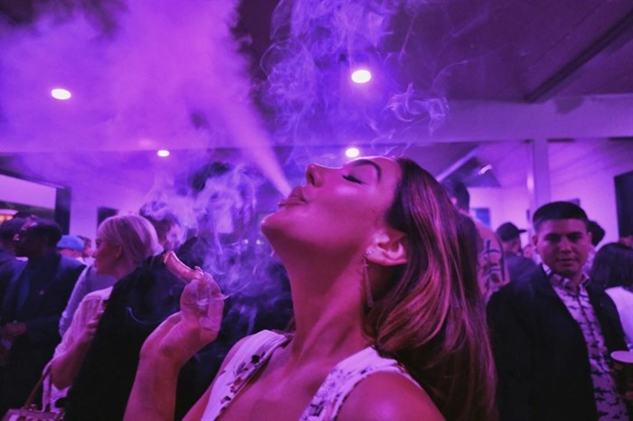 FILE - A guest takes a puff from a marijuana cigarette at the Sensi Magazine party celebrating the 420 holiday in the Bel Air section of Los Angeles on April 20, 2019. Big cannabis companies are backing a new, celebrity-studded campaign to legalize marijuana nationwide, hoping to build pressure on Congress from constituents who haven't always made themselves heard: marijuana users.