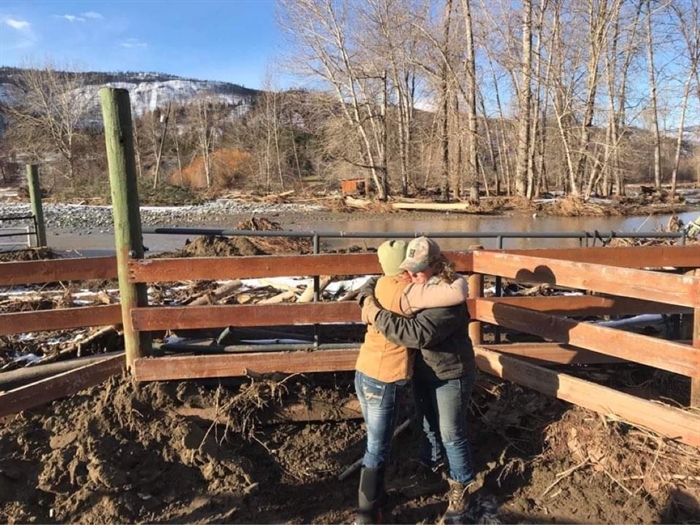 Owner of Bar FX Ranch Rhonda MacDonald (right) hugs her friend Angela following a flood event last week that caused significant property loss to the ranch.