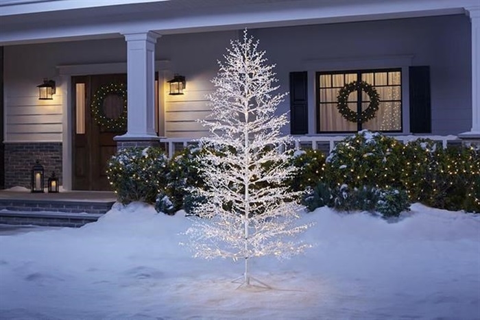 This image provided by The Home Depot shows a white lighted tree. A tree like this one from Home Depot, brings the season home in a welcoming way when placed near the front door. Keep it simple by accenting with natural greenery or go bold with the addition of colorful spotlights and ornaments.