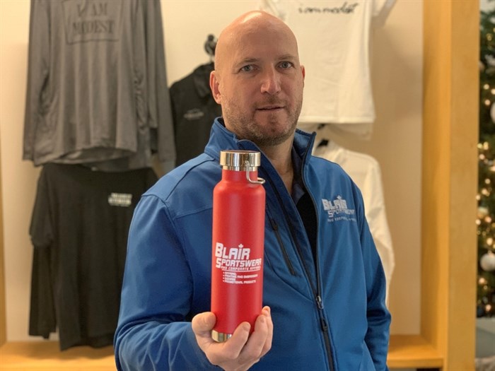 Gordon Blair, owner of Blair Sportswear and Apparel, holds a branded water bottle, one of many items the embroidery company can imprint.