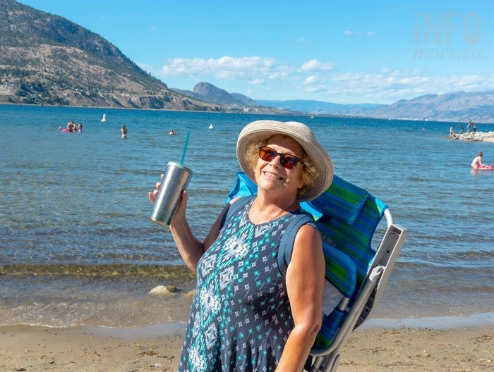 Beach-goer Bella Scholz is seen enjoying a beverage at a beach in Penticton, Sept. 6, 2020, where liquor consumption will be legal again on May 1, 2022.