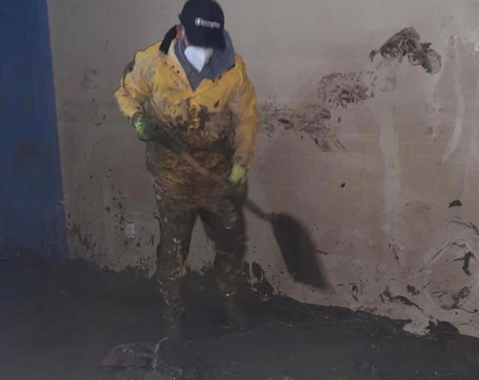 An Endeavor to be Better team member cleans flood damaged home in Merritt.