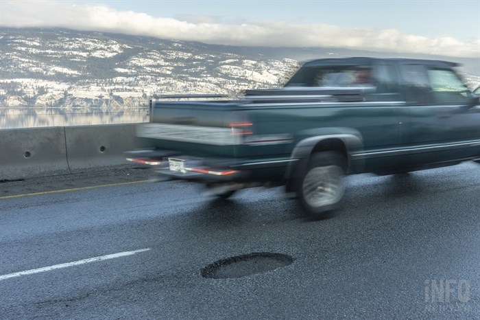 A pickup truck is seen deking out a pothole on Highway 97.