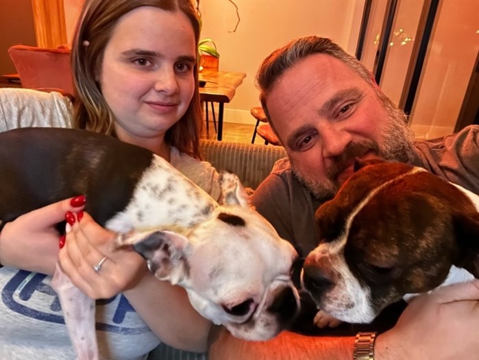 Knaak and his daughter Sara hold their two dogs Sammie-Marie (right) and Leopold.