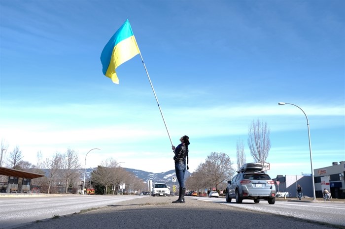 A woman waves a Ukrainian flag in the middle of Harvey Avenue March, 6, 2022.