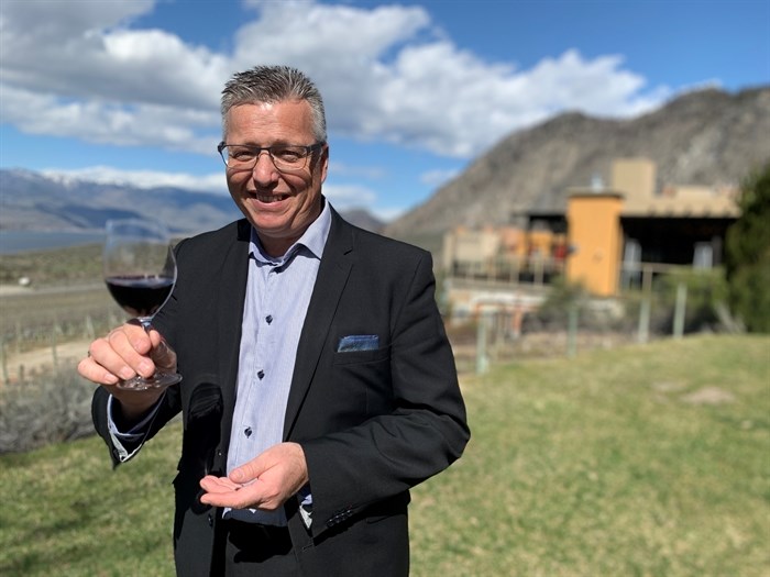 Executive director Daniel Bibby, of Spirit Ridge Resort, offers guests a glass of wine.