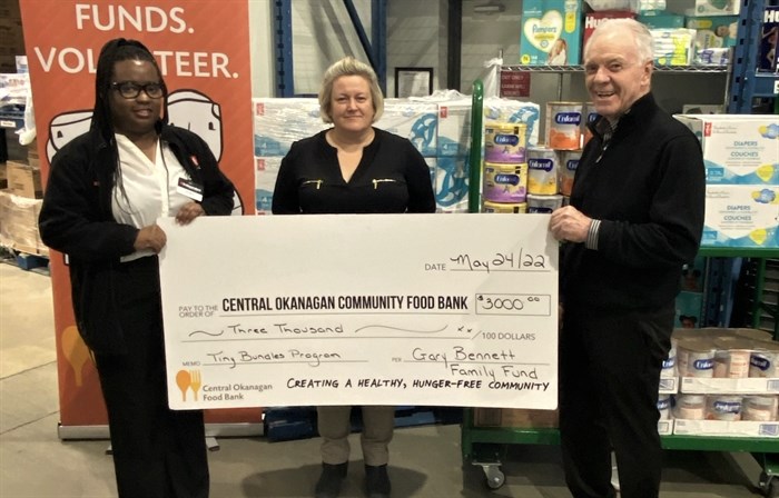 Central Okanagan Community Food Bank staff receive a $3,000 donation for baby formula from Gary Bennett.