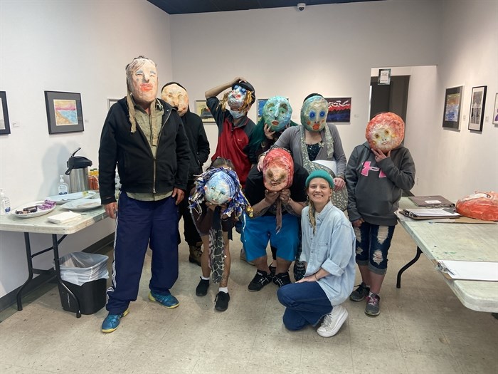 The group of artists pose with their masks.
