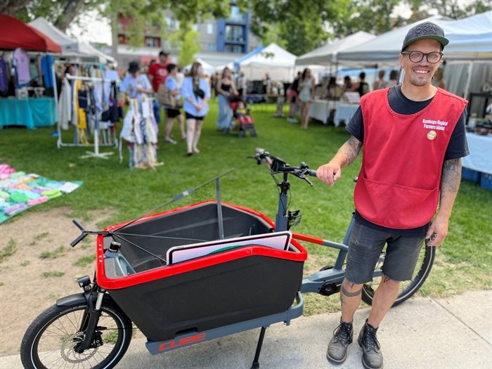 Market manager Greg Unger shows off the new electric front-loading cargo bike.