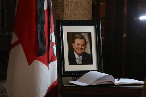 A book of condolences and a photograph of former Finance Minister Jim Flaherty is placed on a table in the lobby of House of Commons on Parliament Hill in Ottawa on Friday, April 11, 2014.