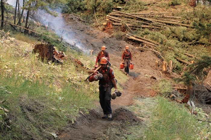 A B.C. Wildfire Service crew is seen hiking on the east flank of the Keremeos Creek wildfire, Aug. 4, 2022.