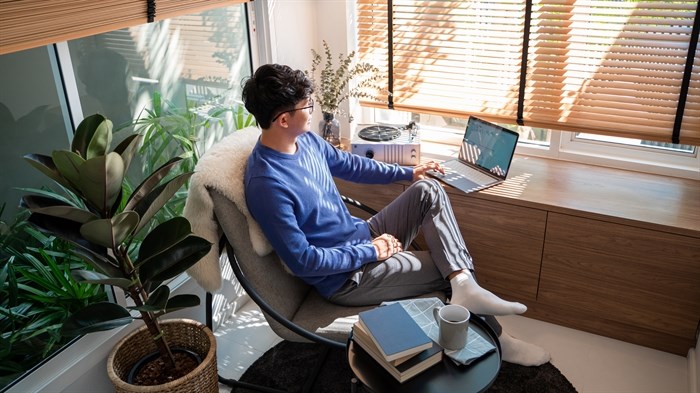 Young male relaxing on computer in living room
