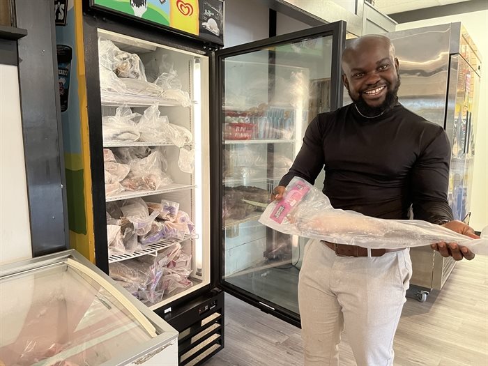 Co-owner of Dede Afro Caribbean Market in Kamloops, Enoch Dubgatey holding up a hake fish.