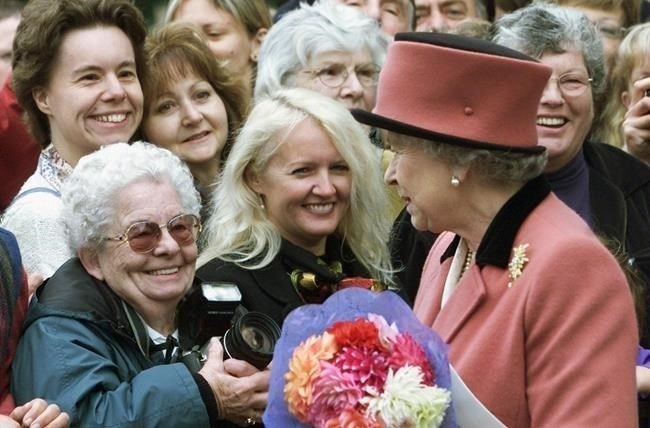 Queen Elizabeth II brings smiles to the faces of well wishers during an impromptu walkabout after attending a church service in Victoria, B.C. on Sunday Oct. 6, 2002.