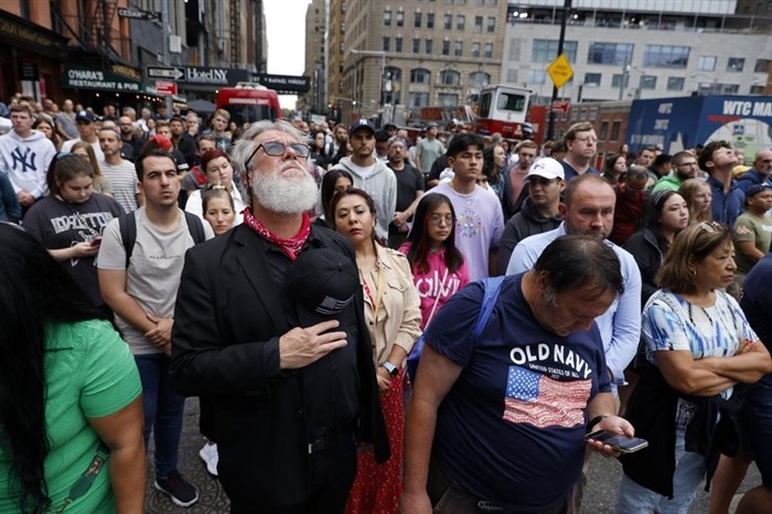 People gather on Cedar Street by the perimeter of the commemoration ceremony during a moment of silence on the 21st anniversary of the September 11, 2001 terror attacks on Sunday, Sept. 11, 2022 in New York.
