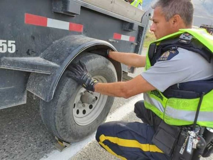 Kamloops RCMP Cpl. Wayne Chung is seen inspecting a trailer in this submitted photo.