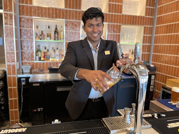 Zubin Toms, banquet manager, pours a beer for guests at Spirit Ridge Resort.