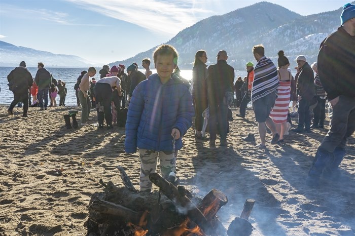 7-year-old Takoda from Summerland was roasting a marshmallow at Sun-Oka Beach during the 2023 Polar Bear Dip.