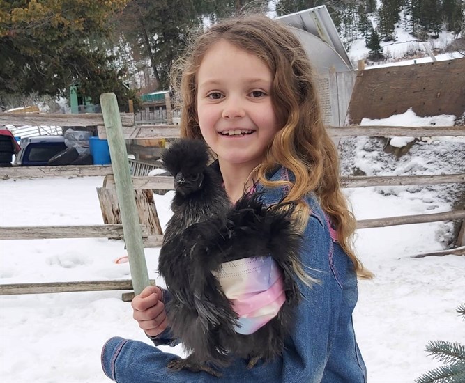 Katrina Fradette with her black silkie chicken called "Bean" on a farm just outside of Kamloops. 