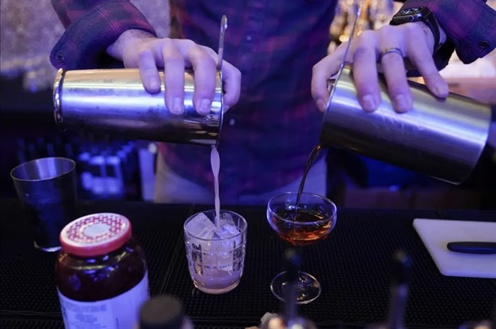 Gregory Megner, general manager and mixologist at Baltimore Spirits Company, pours two mixed drinks - a "Peanut Butter Jelly Thyme" on the left, and a "Best Cup of Coffee in a Manhattan" - containing whiskey distilled on premises, Wednesday, Feb. 8, 2023, in Baltimore.