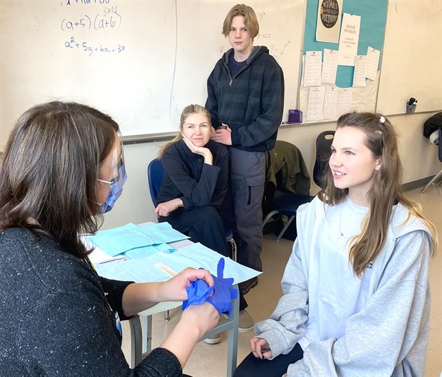 Dental hygiene assistant Maruie Giella, left, of Interior Health prepares to examine Vlada Varnytska  teeth. Watch in the background are her mother Vitalina and brother Ustym. There was a special oral health clinic for Ukranian youth and their families.
